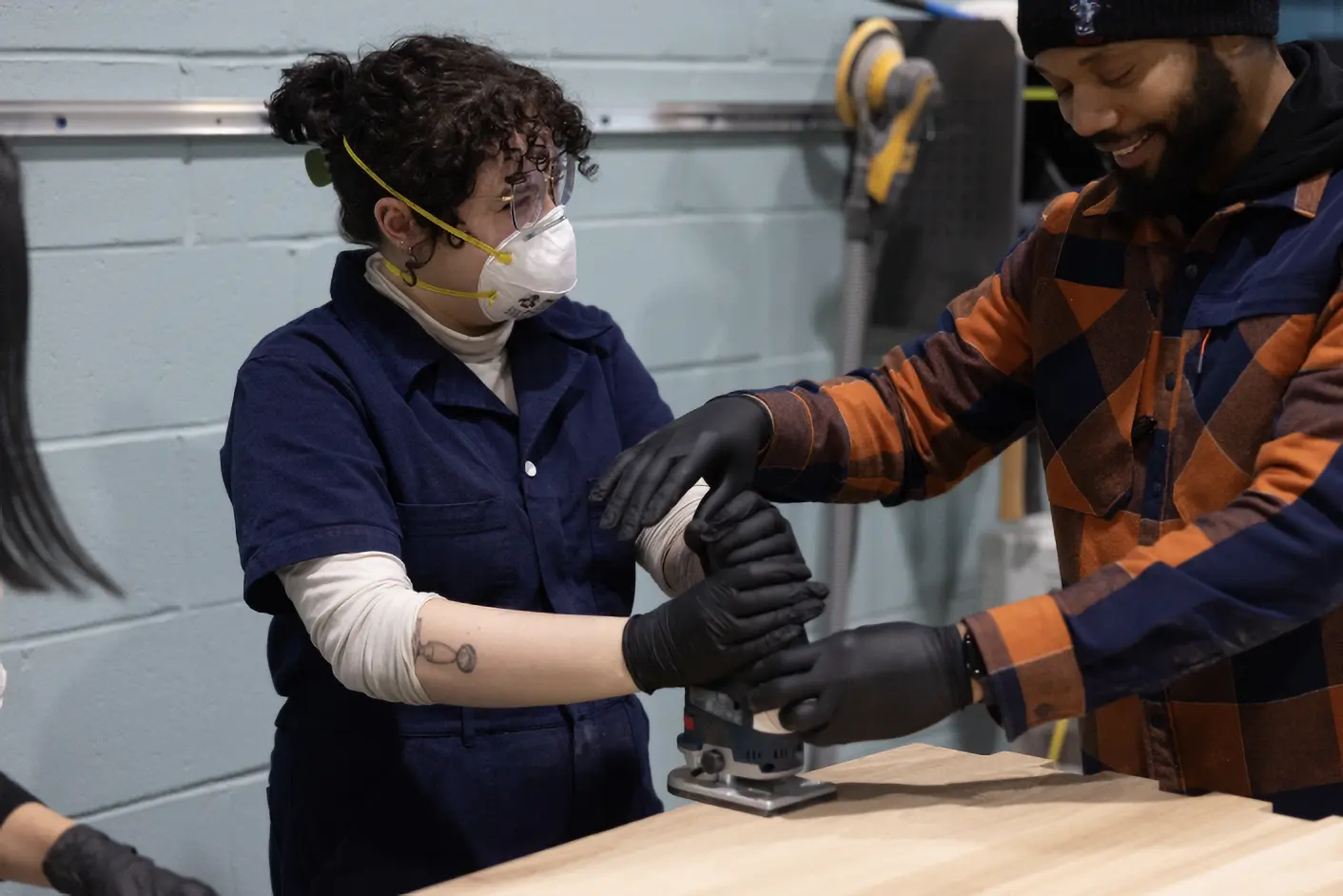 A Freedom Reads Team member learns how to use a wood router to curve the edge of a Freedom Library at the Revival Workshop in New Orleans.