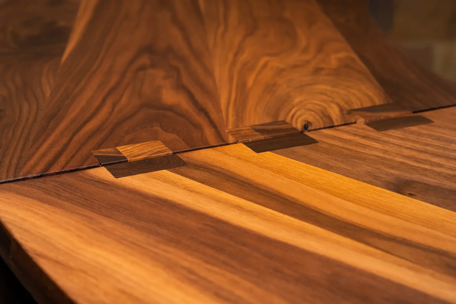 A close-up shot of the finger joints fitting together the walnut wood panels in an assembled Freedom Library installed at Woodbourne Correctional Facility.