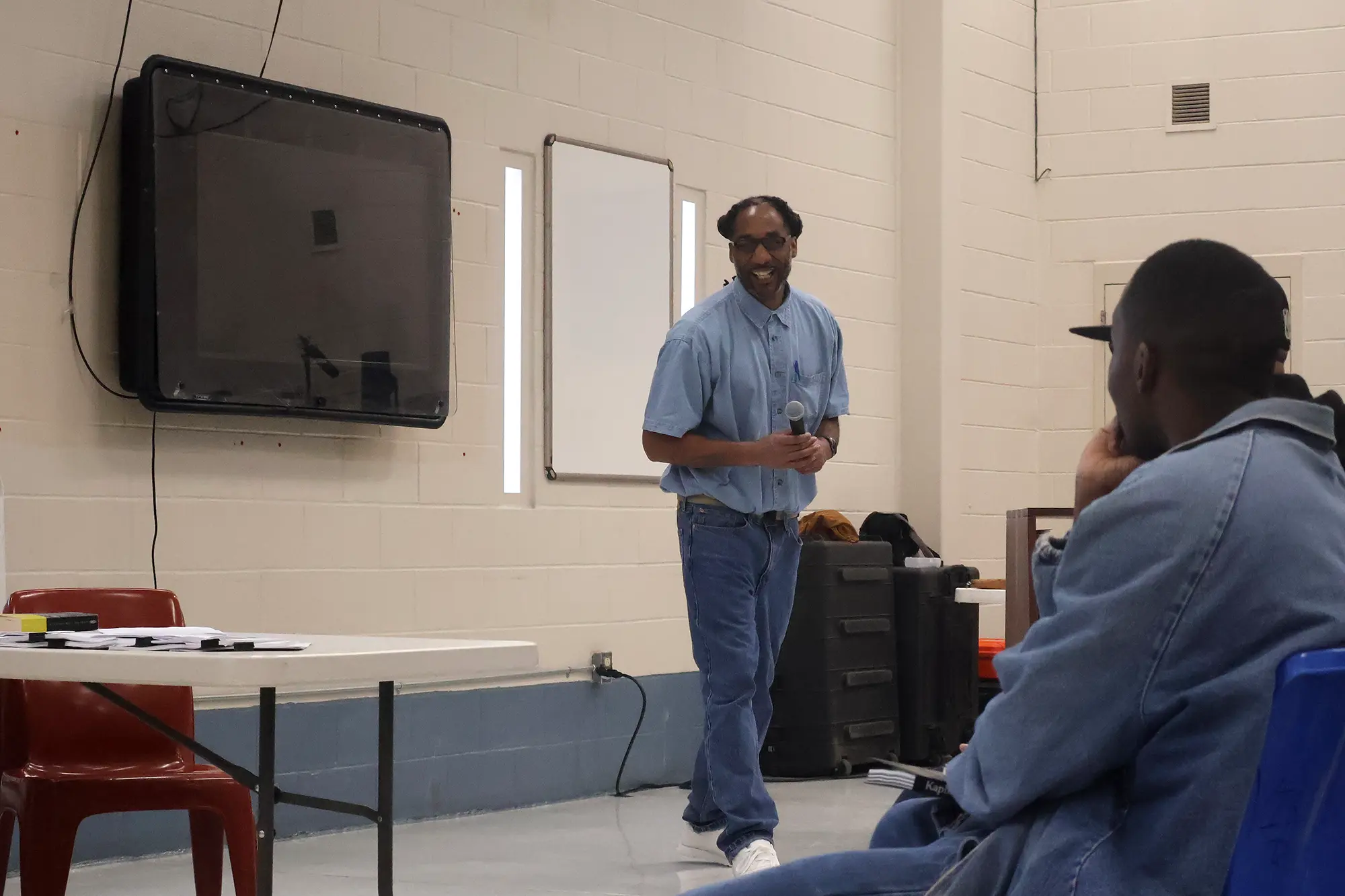 Anthony, a Freedom Library Patron at Dillwyn Correctional Center in Virginia, smiles at his audience as he welcomes Freedom Reads Founder & CEO Reginald Dwayne Betts to the stage for his March 4th performance of his solo show FELON: An American Washi Tale.