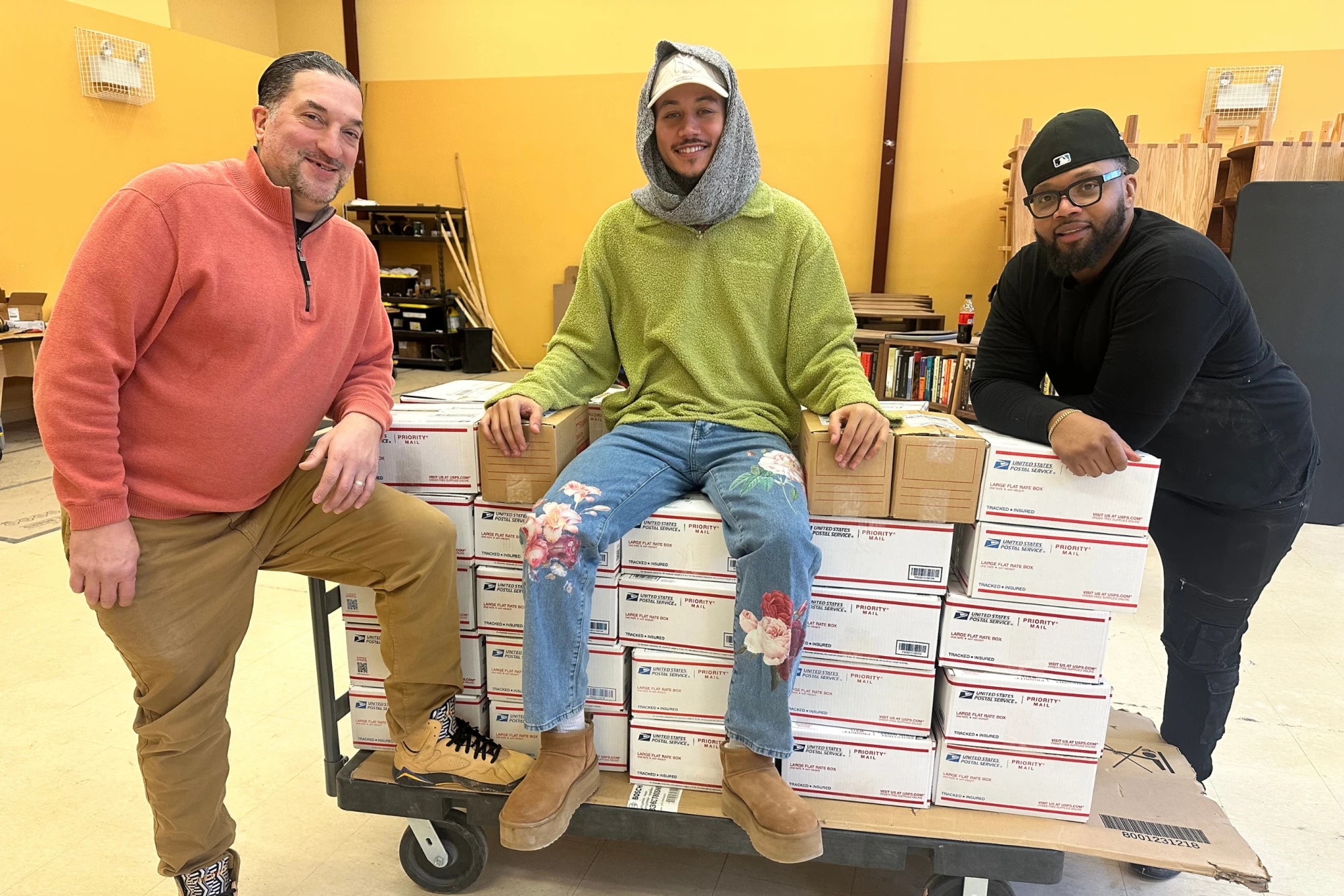 Freedom Reads team members (from left to right) Jimmy Flynn, David Perez DeHoyos, and Michael Byrd posing with boxes of books.