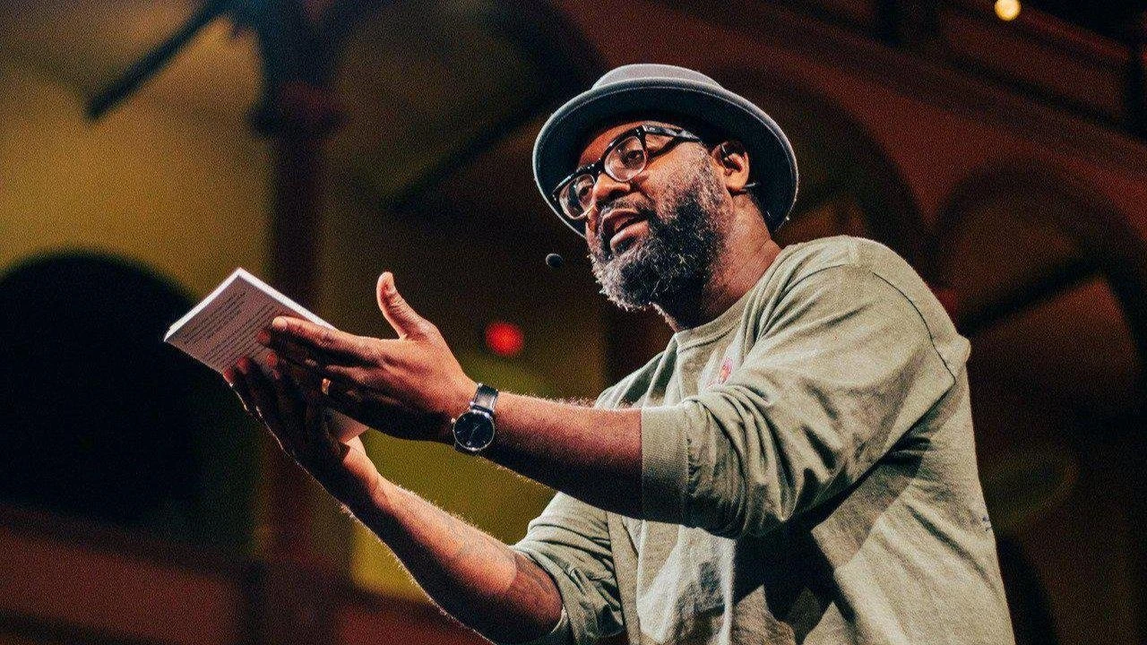 Freedom Reads Founder & CEO Reginald Dwayne Betts holds a book during his performance.