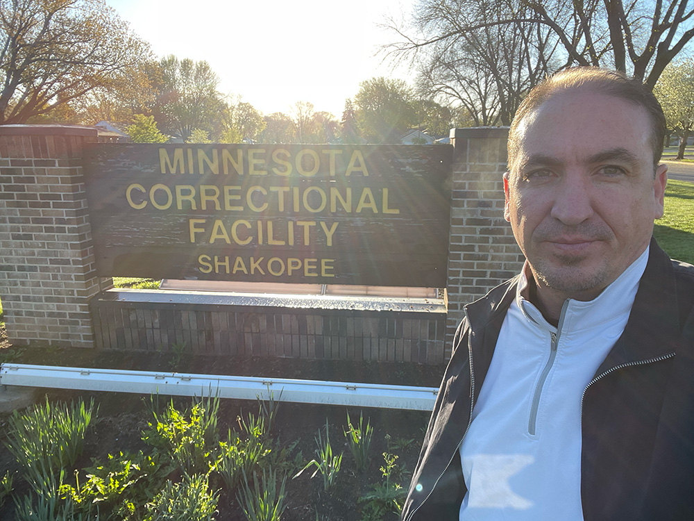 Freedom Reads Communications Manager Steven Parkhurst takes a selfie with the sign outside of Minnesota Correctional Facility - Shakopee.