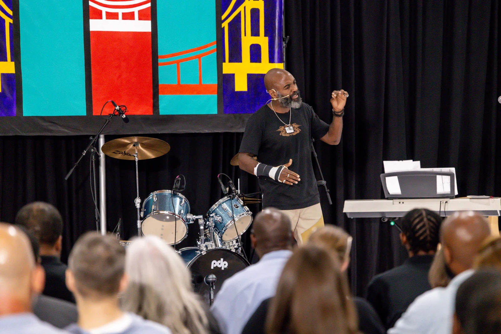 Dwayne speaks on a stage in front of a crowd at Green Rock Correctional Center.