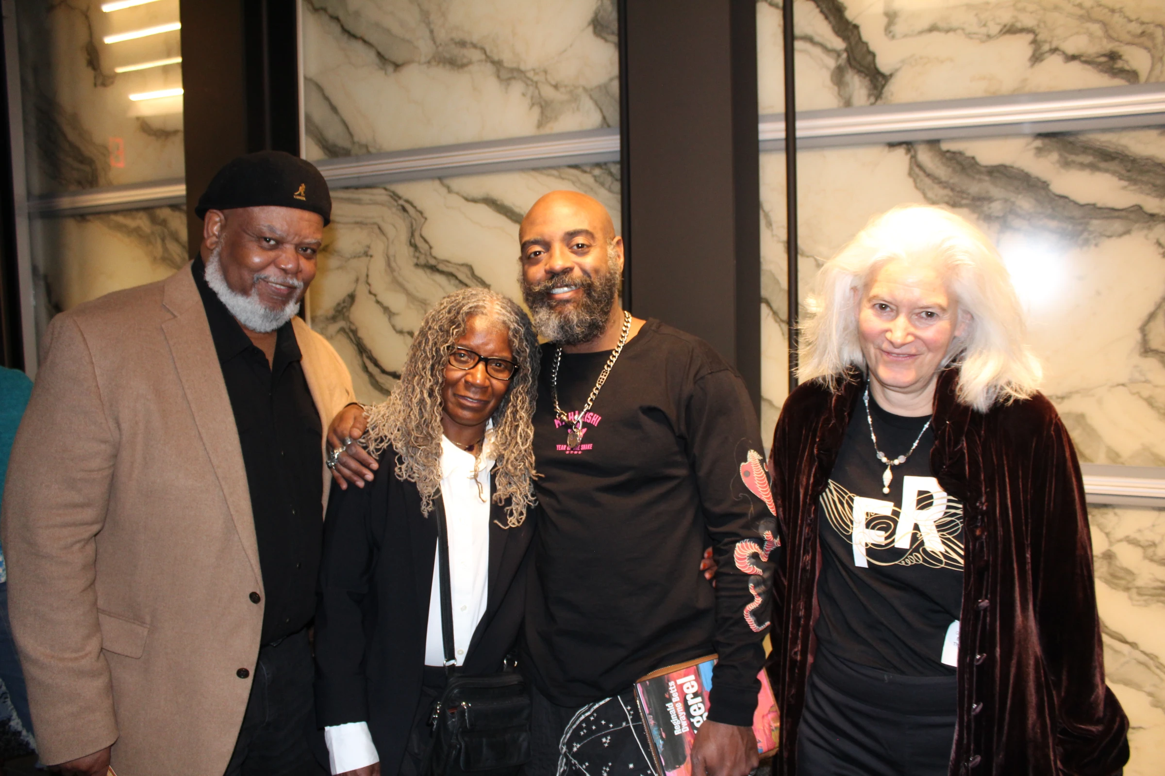 Freedom Reads Founder & CEO Reginald Dwayne Betts stands smiling with three people, family and friends, after his March 4th, 2025 performance at the Perelman Performing Arts Center.