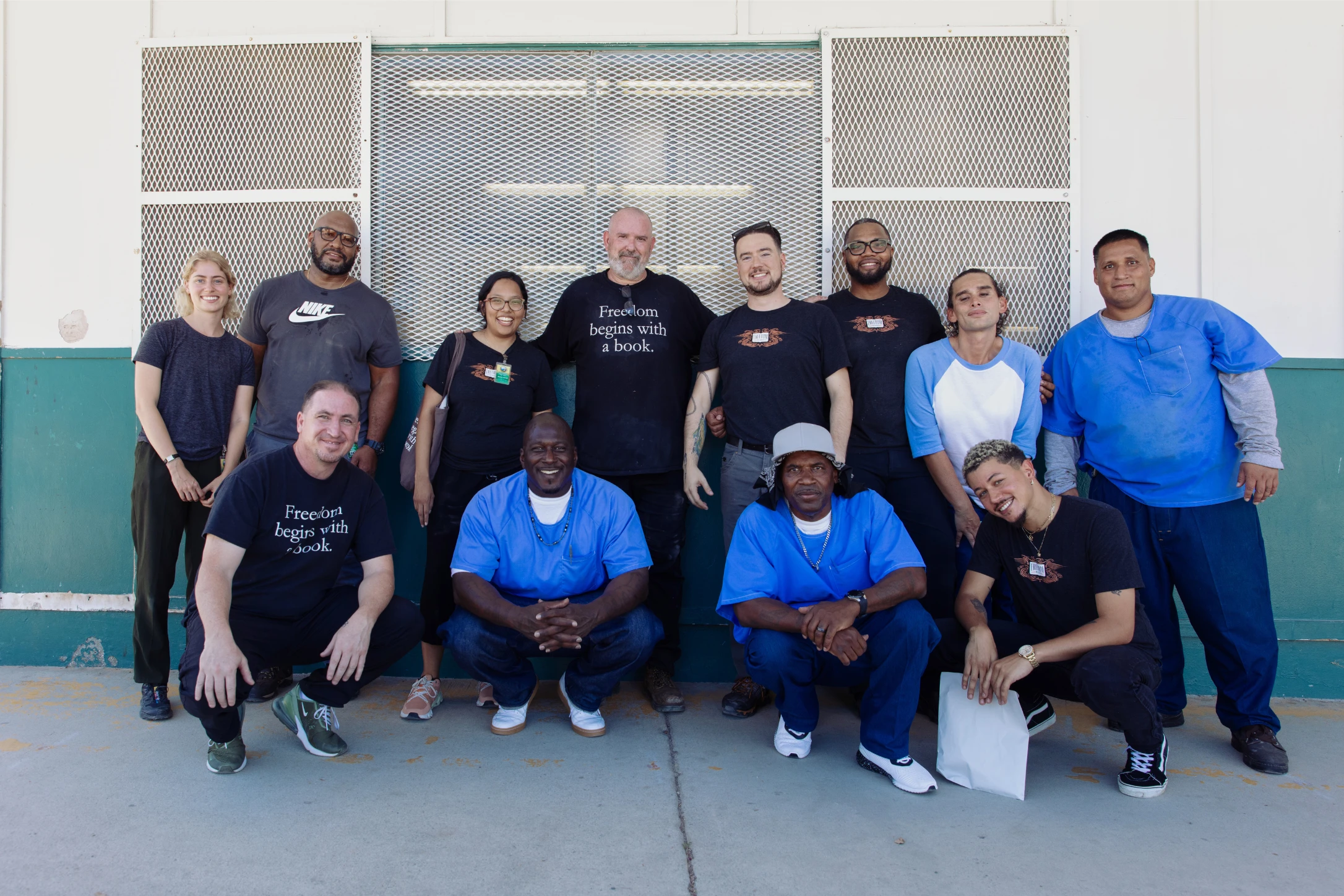 The Freedom Reads team and Freedom Library Patrons at the California Institution for Men smile for a photo.