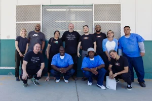 The Freedom Reads team and Freedom Library Patrons at the California Institution for Men smile for a photo.