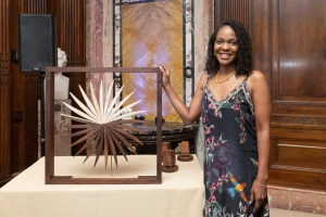Imani Perry stands, smiling with the Inside Literary Prize award.