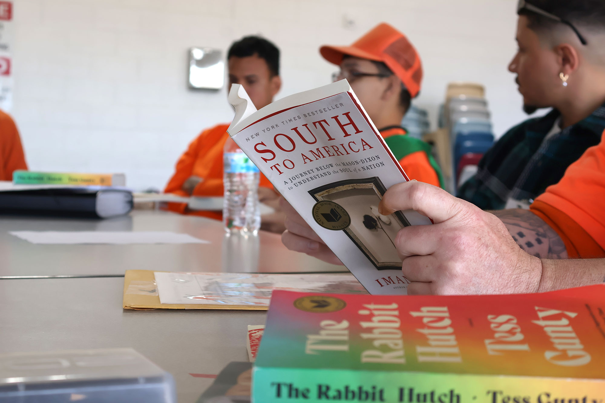 Detail of table with inmates reading and discussing South to America by Imani Perry and The Rabbit Hutch by Tess Gunty