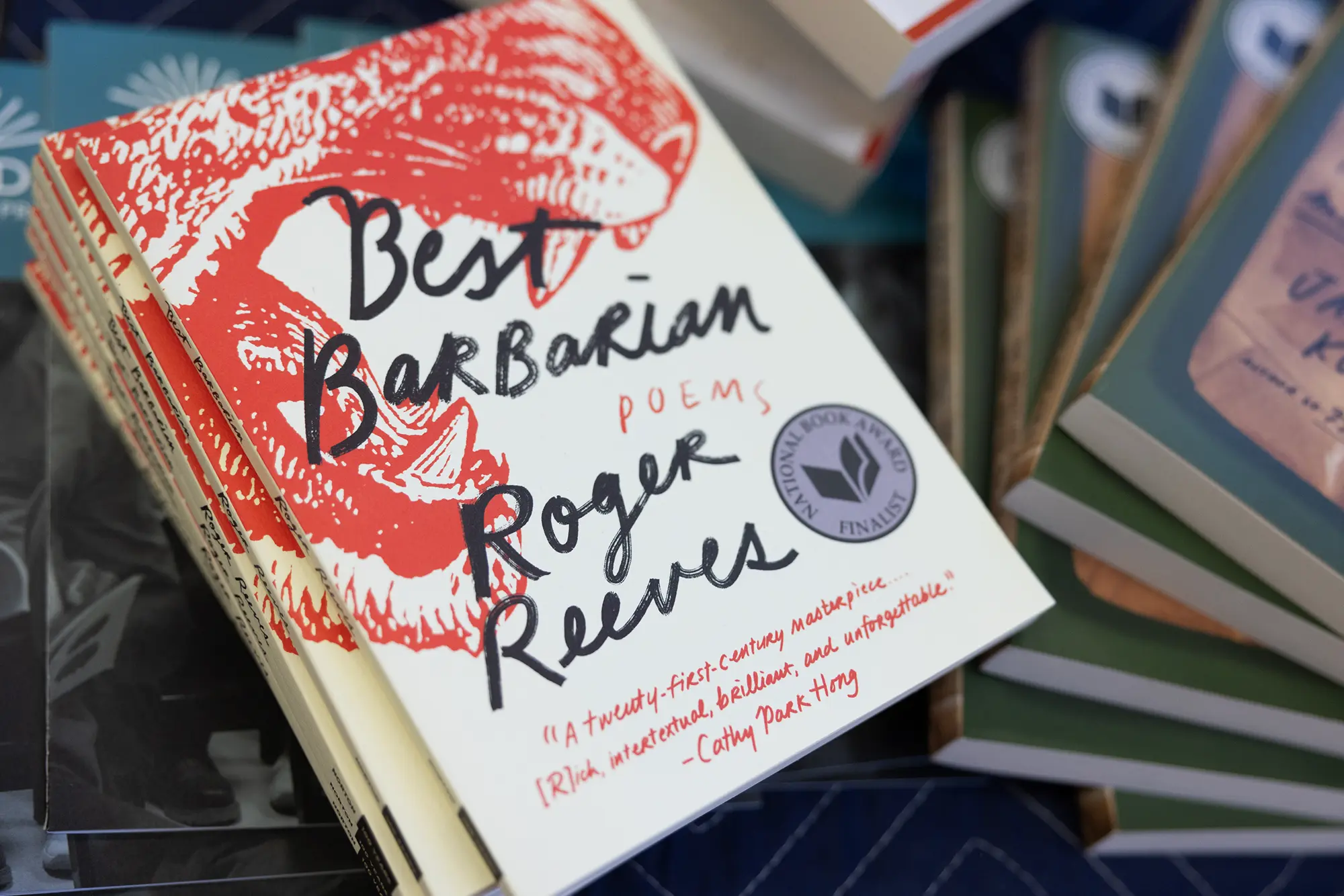 A closeup photo of book cover featuring scrawled handwriting and a large red detail wild cat illustration for Best Barbarian by Roger Reeves