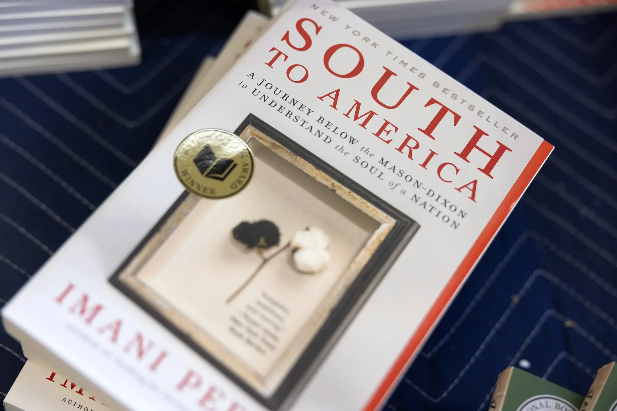 A closeup photo of book cover featuring framed black and white cotton for South to America by Imani Perry