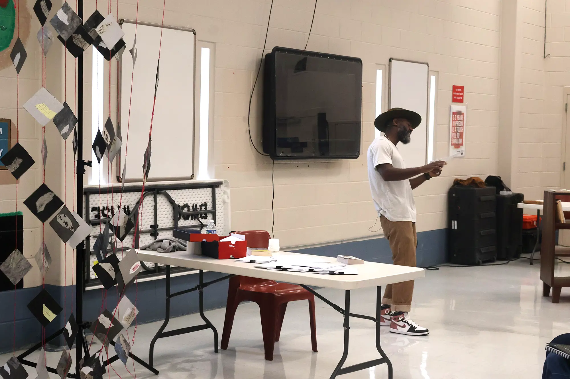 Freedom Reads Founder & CEO Reginald Dwayne Betts transforms the front of the recreational room of Dillwyn Correctional Center in Virginia into a theatrical stage with a portable paper kite stand.